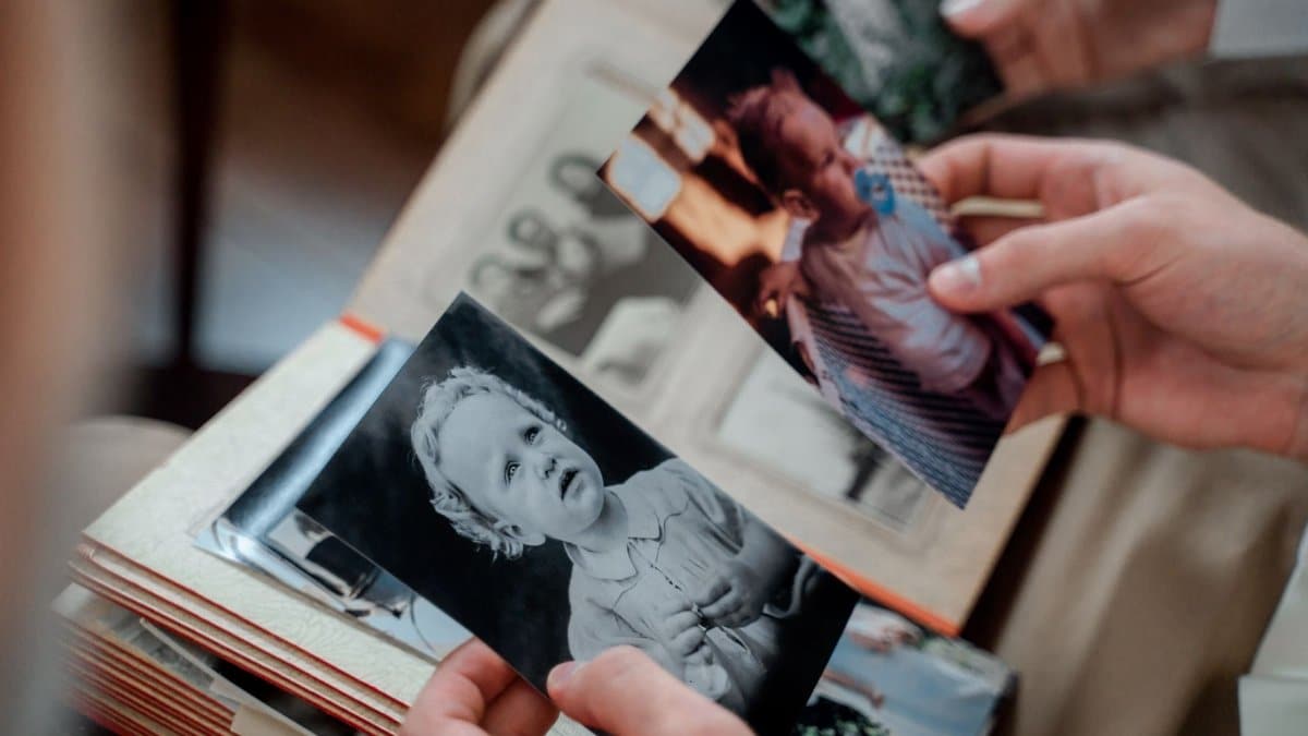 Close-up of hands examining nostalgic family photos in an album.