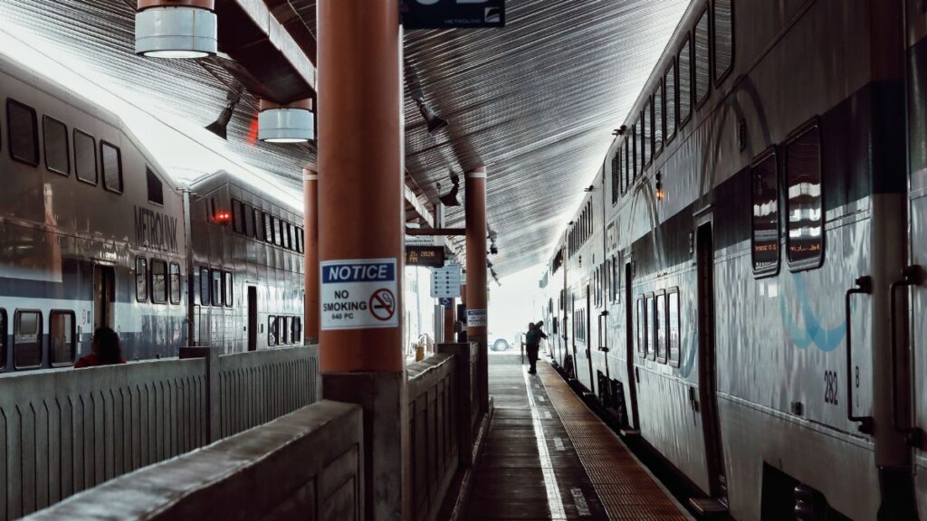 Two commuter trains at a Los Angeles station platform, showcasing bustling urban transit.