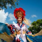 Vibrant dancer in traditional costume performing at Miami street festival parade.