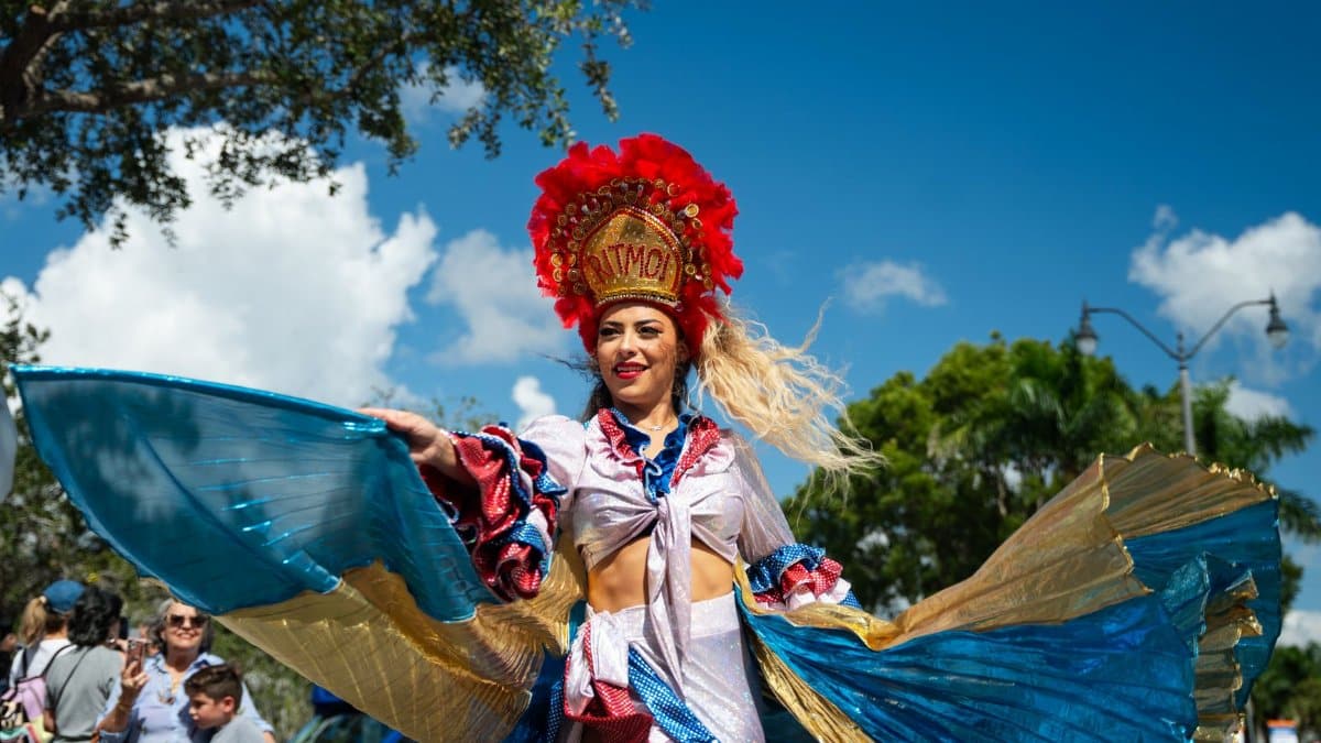 Vibrant dancer in traditional costume performing at Miami street festival parade.