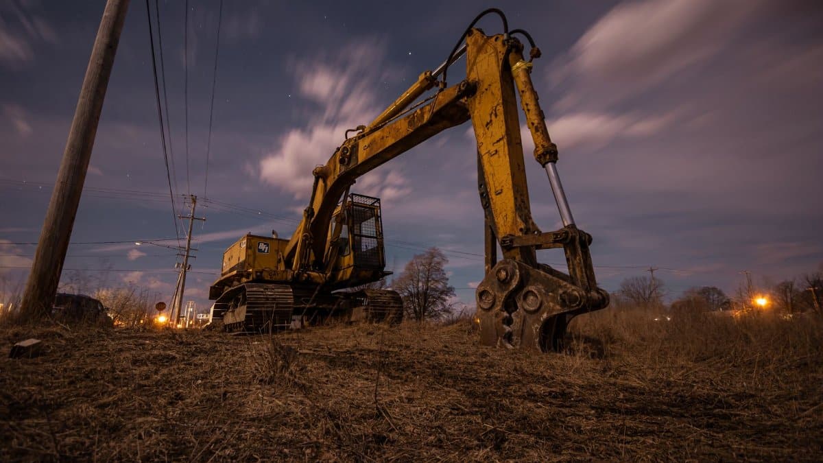 A powerful excavator sits in a field under a starry sky in Greenville, Michigan.