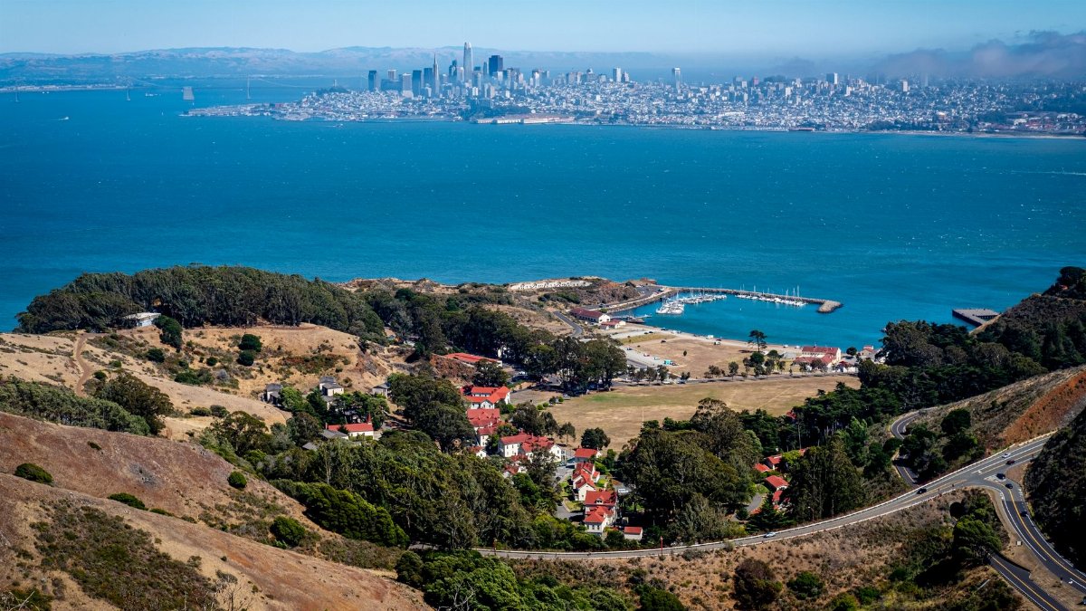 Stunning aerial view of San Francisco Bay with city skyline and lush green hills.