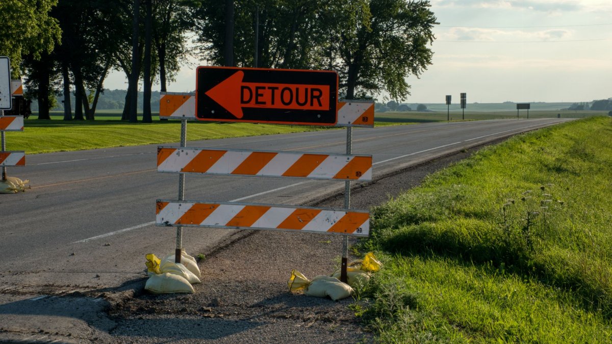 Roadside detour sign with arrow in rural Plainview, MN, under clear skies. Perfect for travel and road maintenance themes.