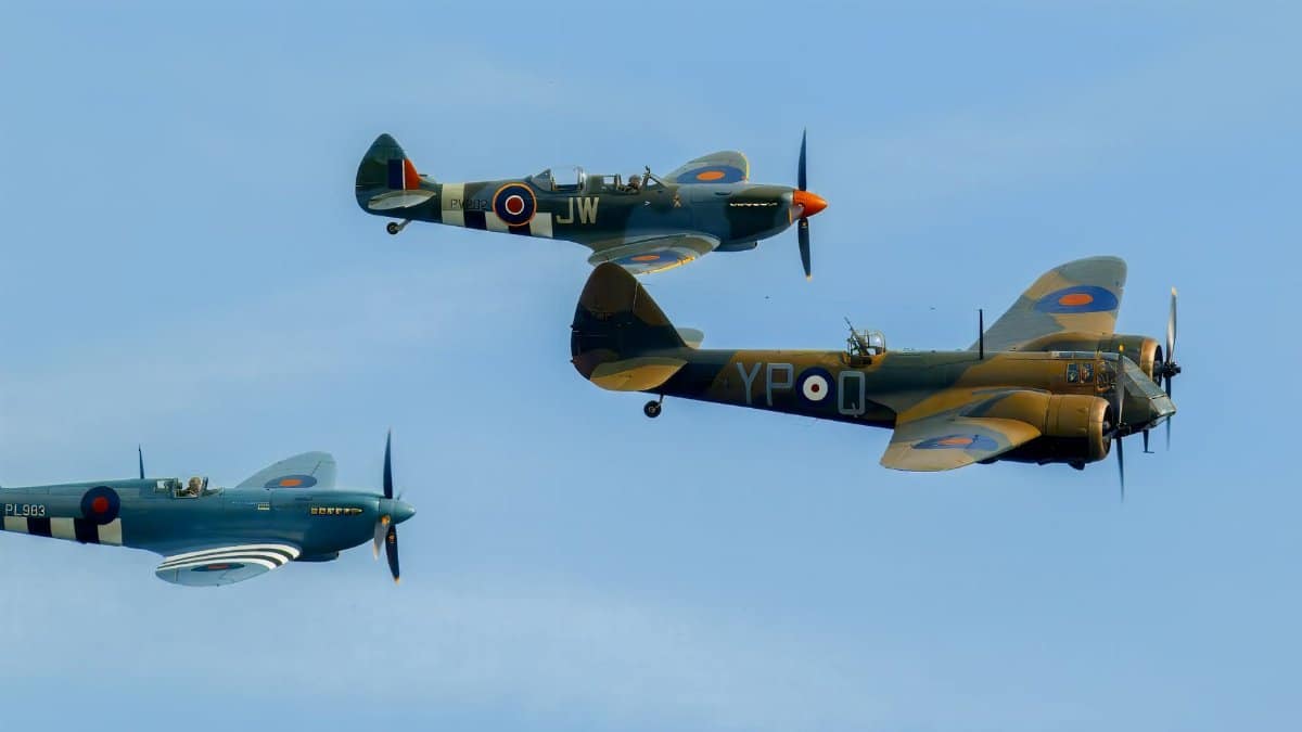 A stunning image of three vintage WWII fighter planes against a clear blue sky, showcasing historic aviation.