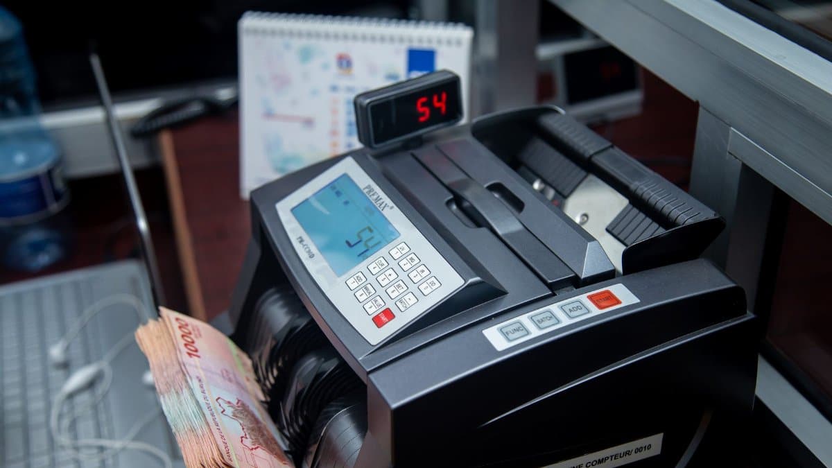 Automatic money counter in a modern office counting banknotes efficiently.