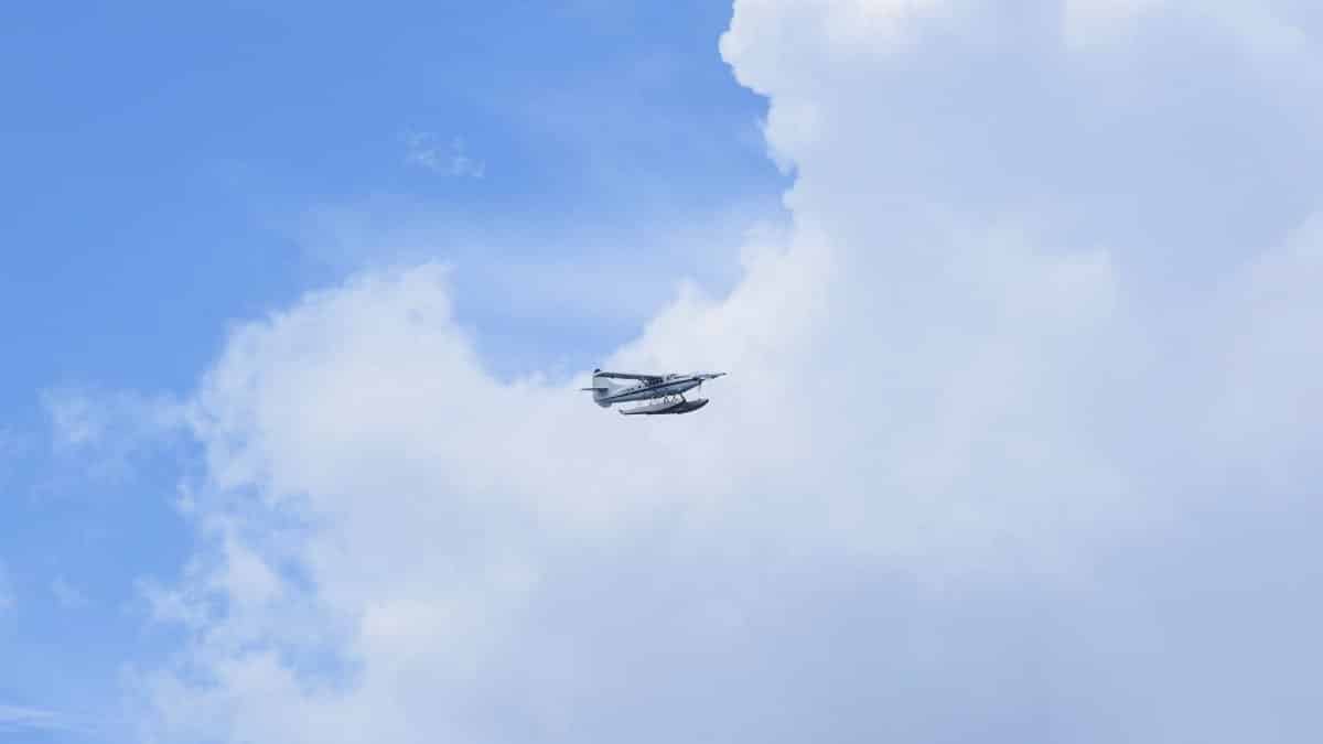 Seaplane flies high above fluffy clouds in Monroe County, FL.