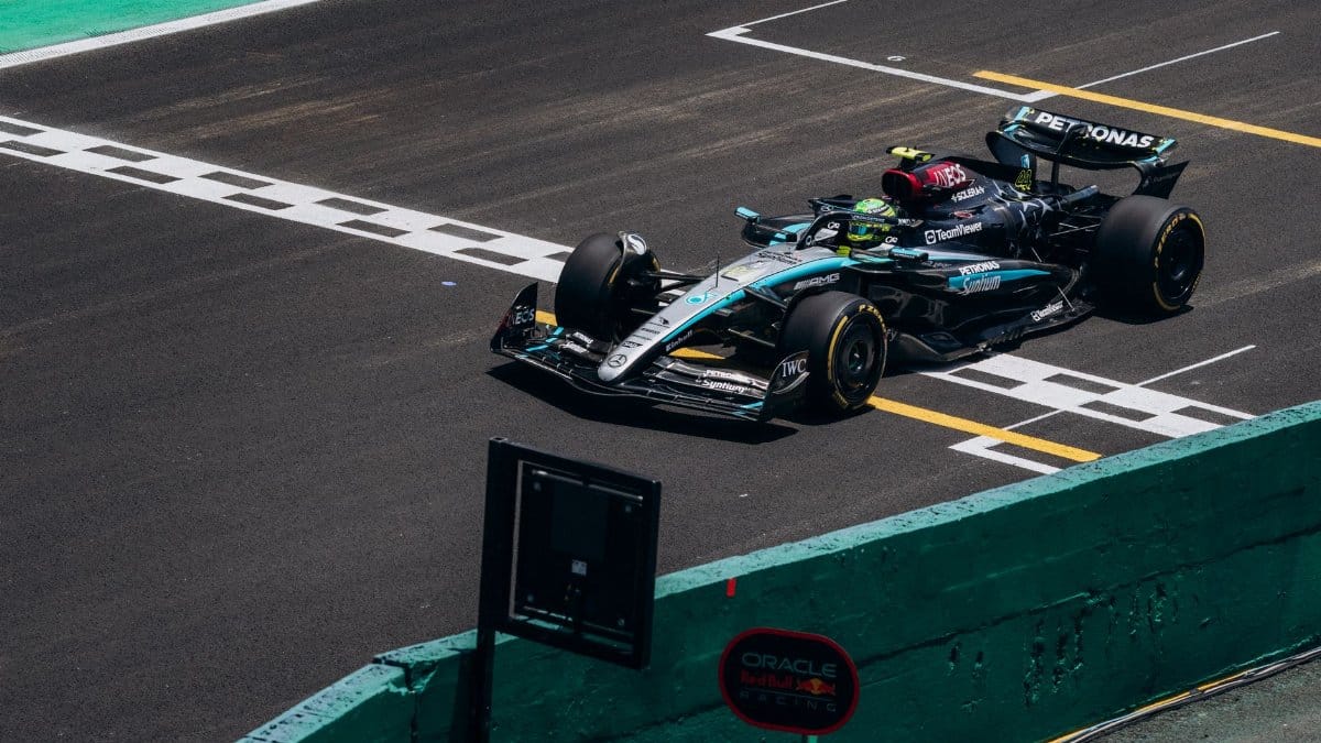 High-speed Formula 1 car crossing the finish line on a race track during the day.