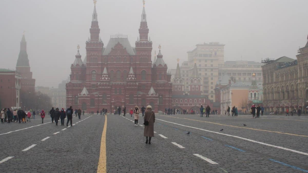 A foggy scene capturing the architecture and atmosphere of Moscow's Red Square with visitors.