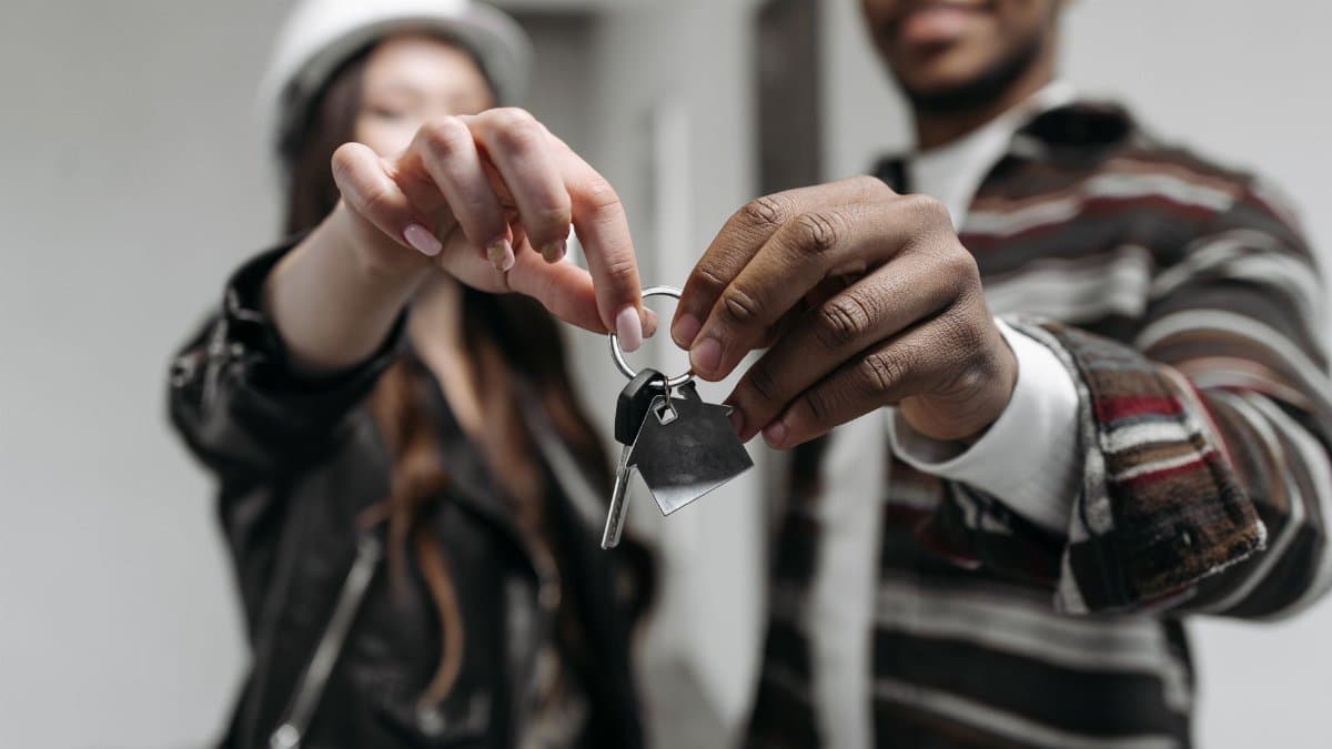 Close-up of a couple joyfully holding keys to their new home, symbolizing new beginnings and home ownership.