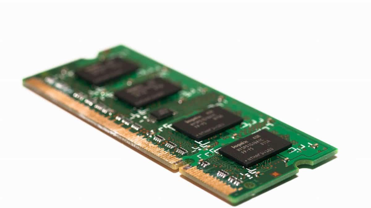 Detailed view of a green electronic memory module against a white background, showcasing modern technology.