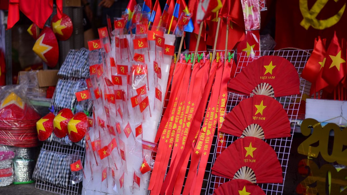Colorful display of Vietnamese flags and fans celebrating national pride at a local market.