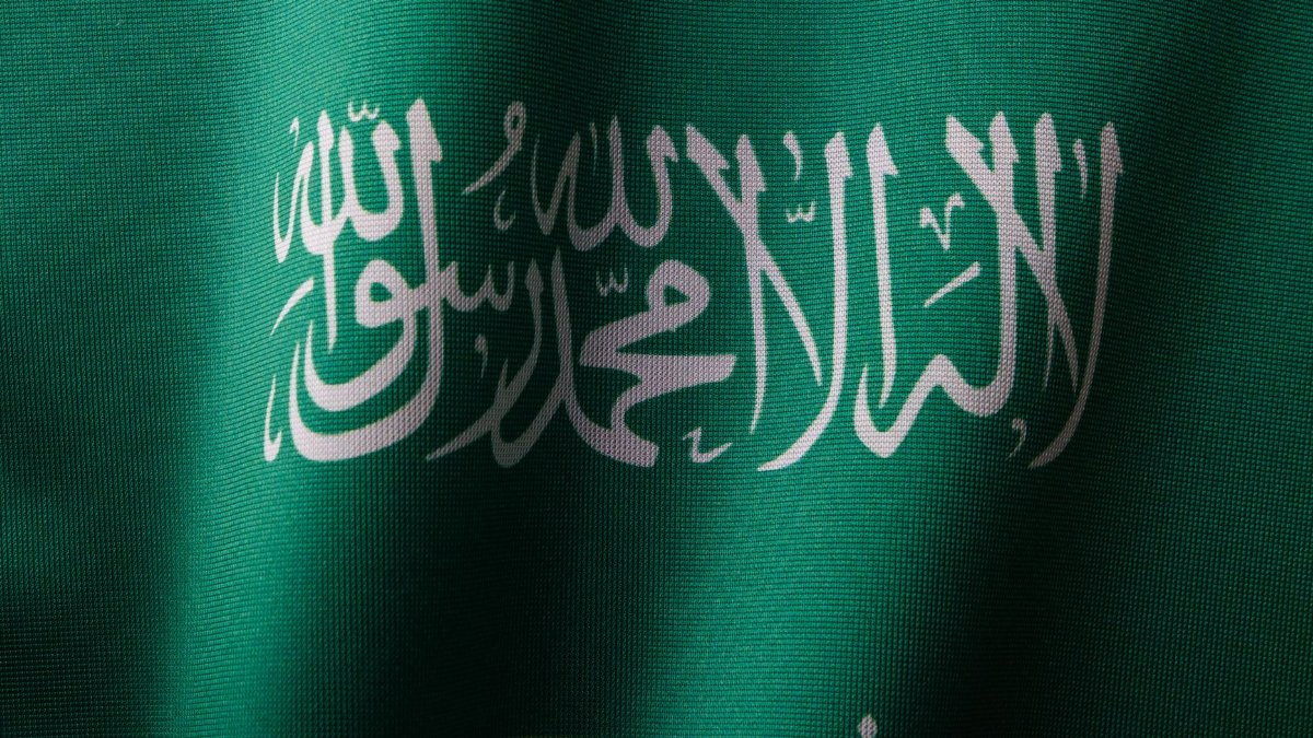Detailed close-up of the Saudi Arabian flag showcasing the elegant Arabic script and vibrant green color.