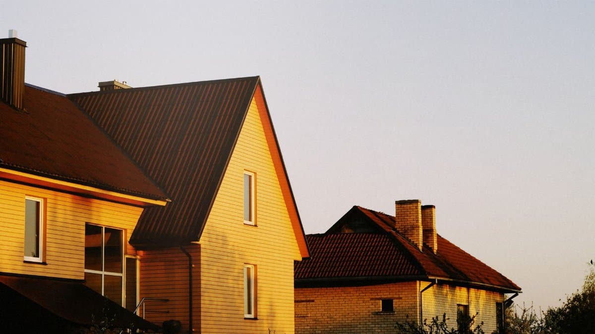 Warm light bathes cozy houses at sunset, creating a serene and picturesque scene.