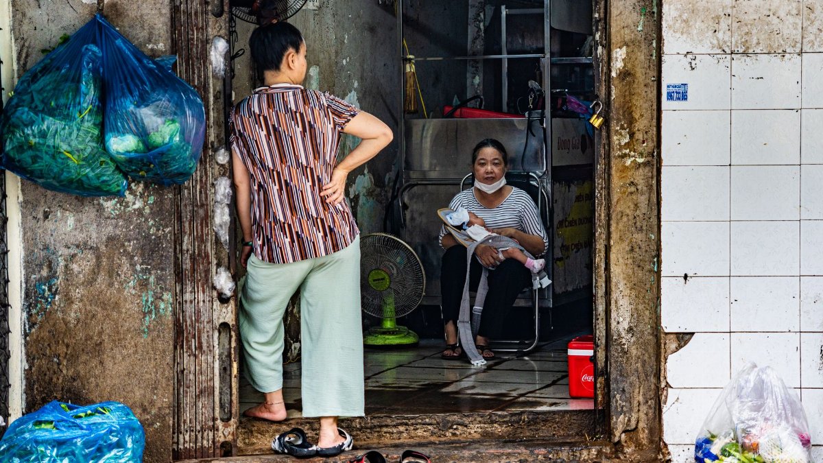 Authentic urban street scene depicting daily life with a mother and child in a doorway.