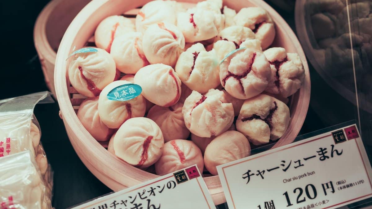 Delicious Japanese Char Siu pork buns displayed in a bamboo steamer with price tag.