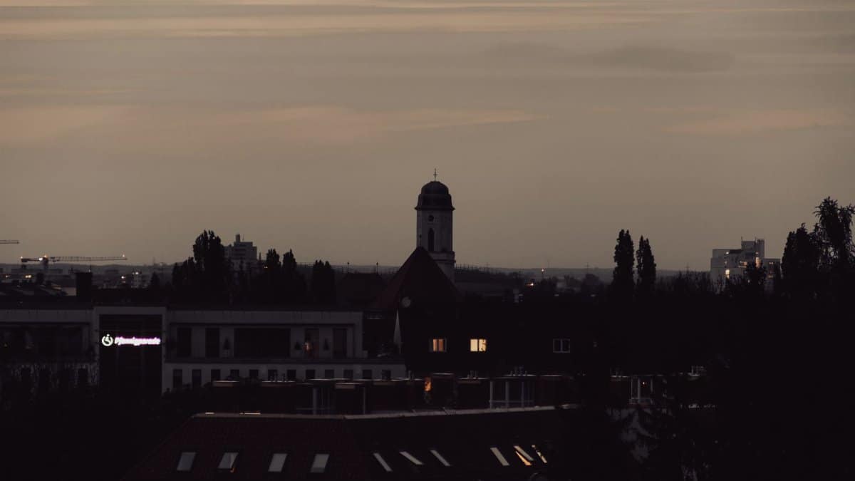 A serene view of Munich's skyline at twilight, featuring city silhouettes and a tranquil evening sky.