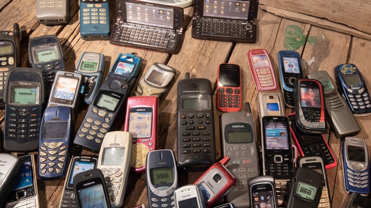 An assortment of retro mobile phones displayed on a rustic wooden surface, showcasing nostalgia.