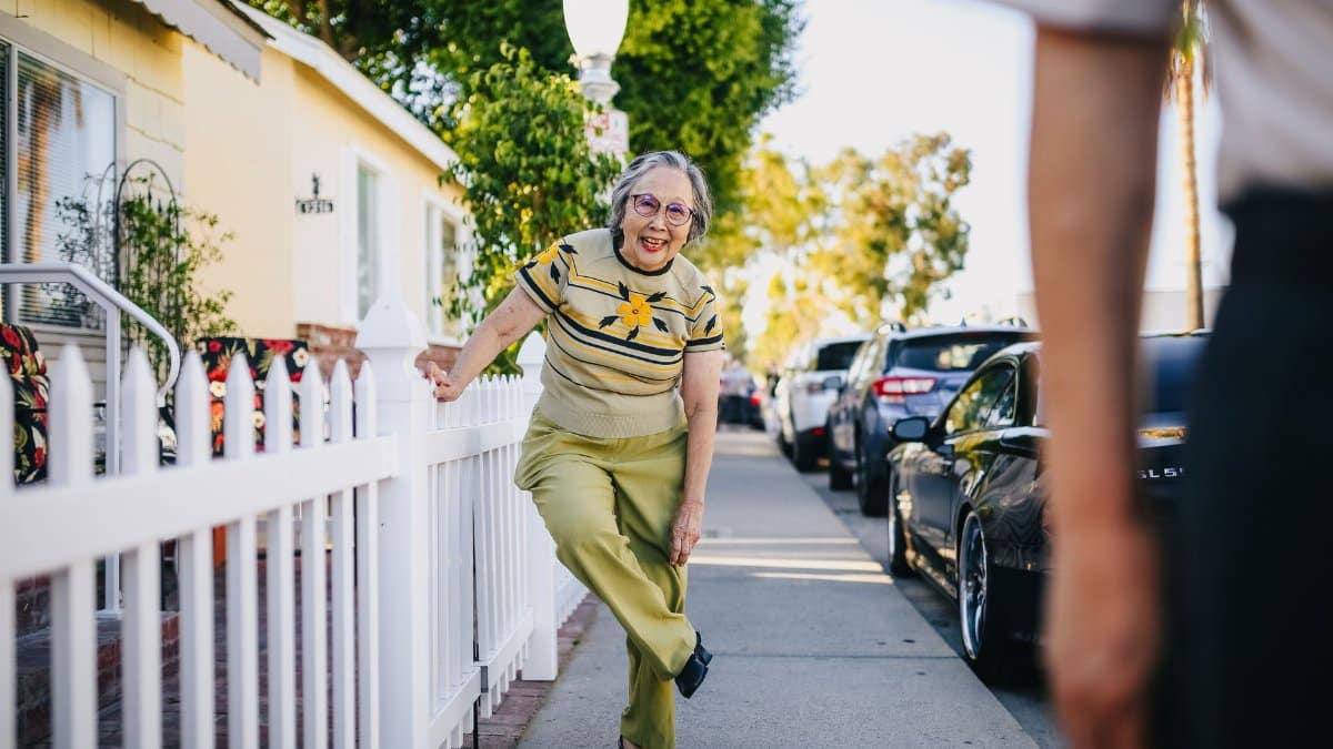 Happy senior woman having fun on a sunny day in a suburban street.