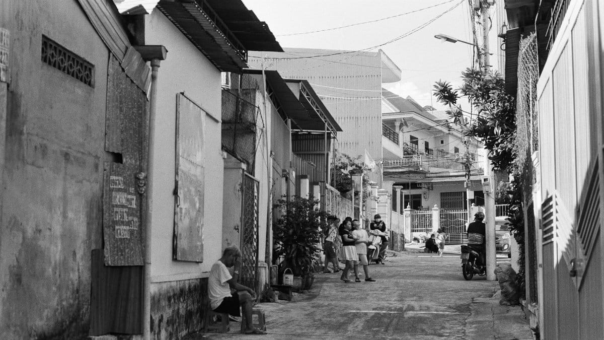A vibrant scene of street life in Pleiku, Vietnam, featuring people, architecture, and motorcycles.