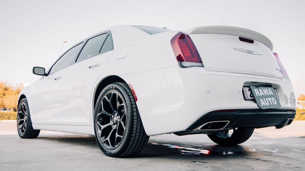 A rear view of a sleek white Chrysler 300 parked in sunny Erbil, Iraq.
