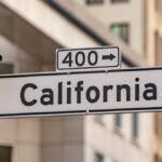 Street sign for California with traffic light in cityscape. Urban navigation and signage theme.