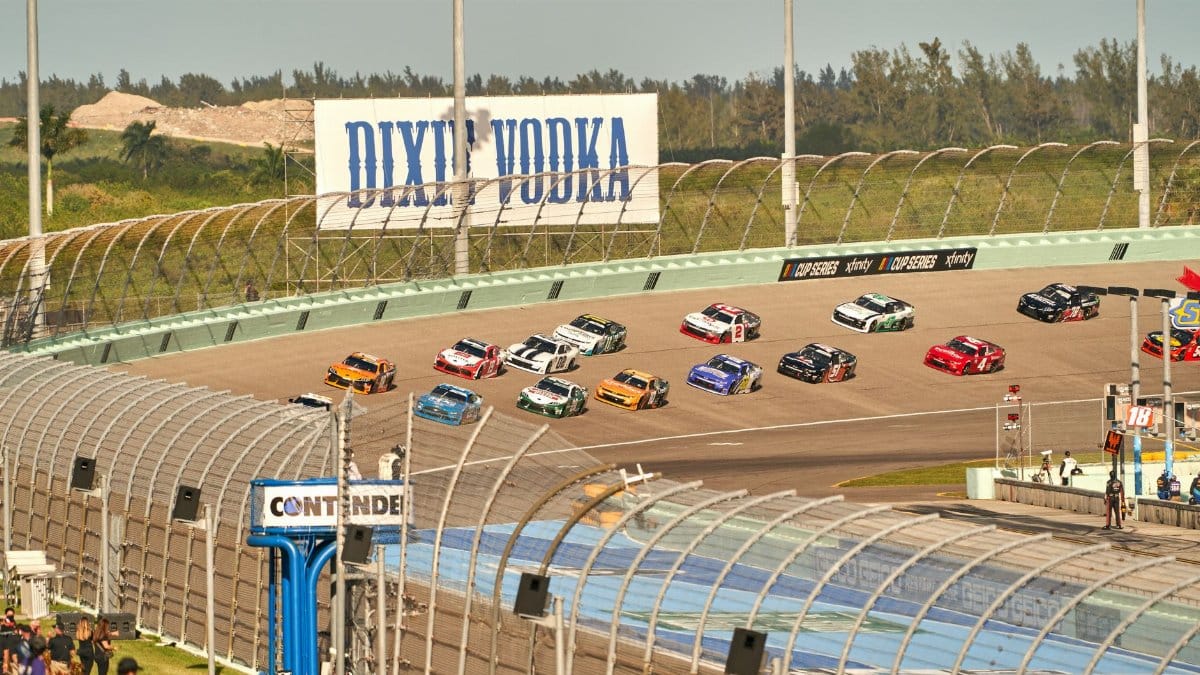 High-speed NASCAR race on a sunny day at the iconic Miami speedway track.
