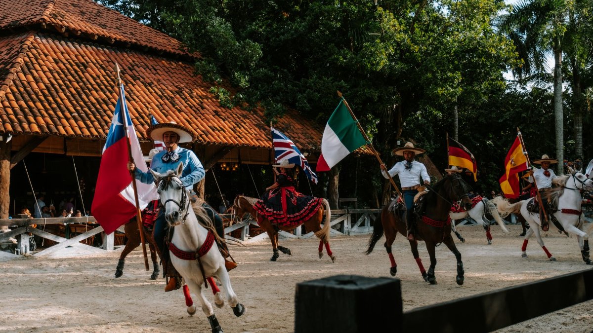 Vibrant equestrian show in Cancun featuring riders with international flags in traditional attire.
