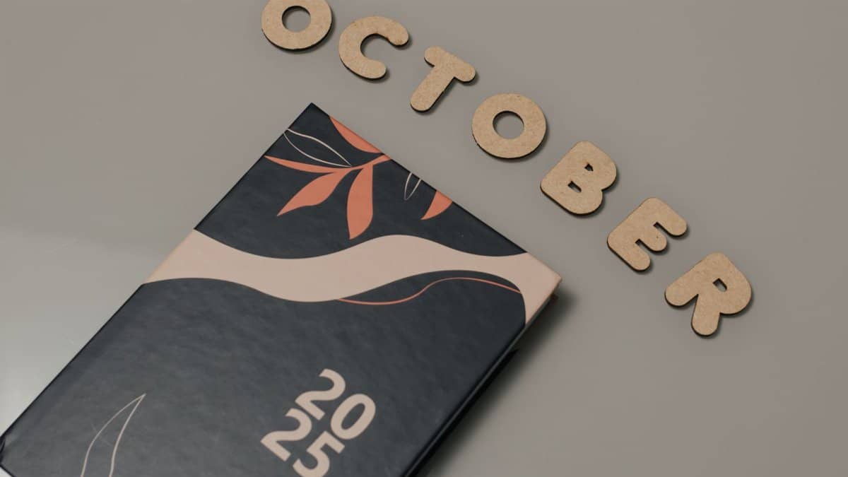 A sleek planner with October letters and 2025 date, set on a neutral surface.
