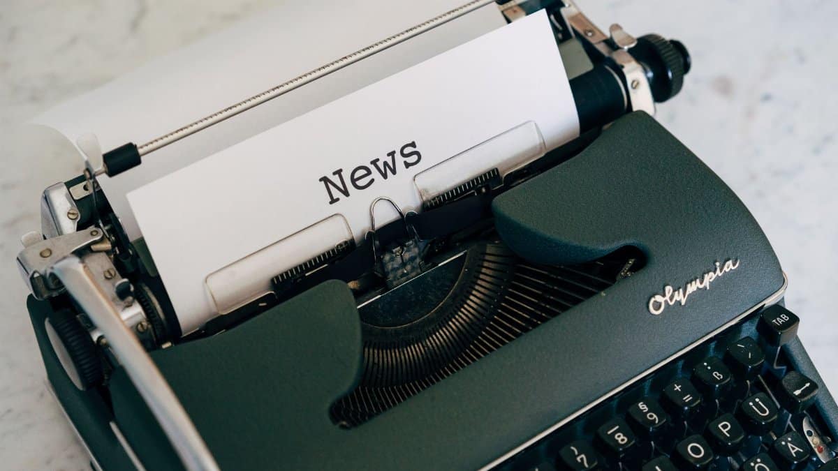 Close-up of an antique typewriter with 'News' on paper.