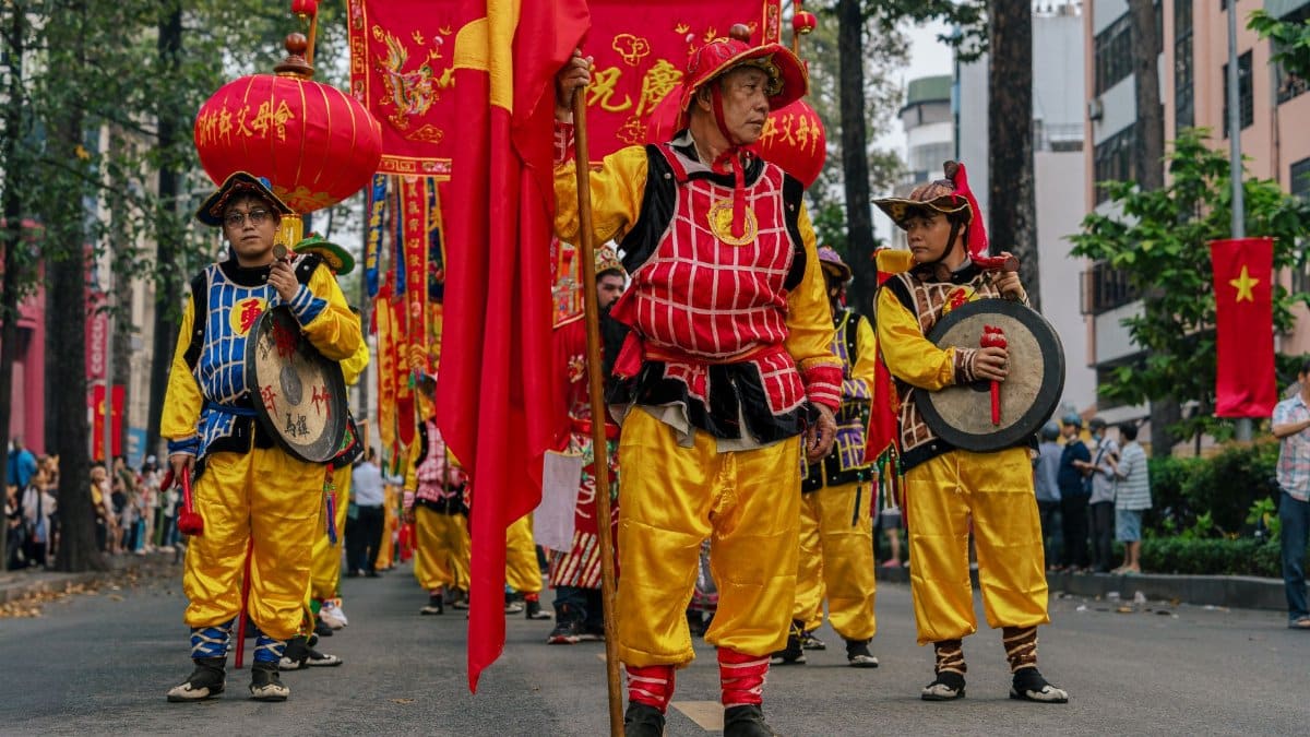 Colorful traditional Vietnamese parade in Ho Chi Minh City with participants in vibrant costumes.