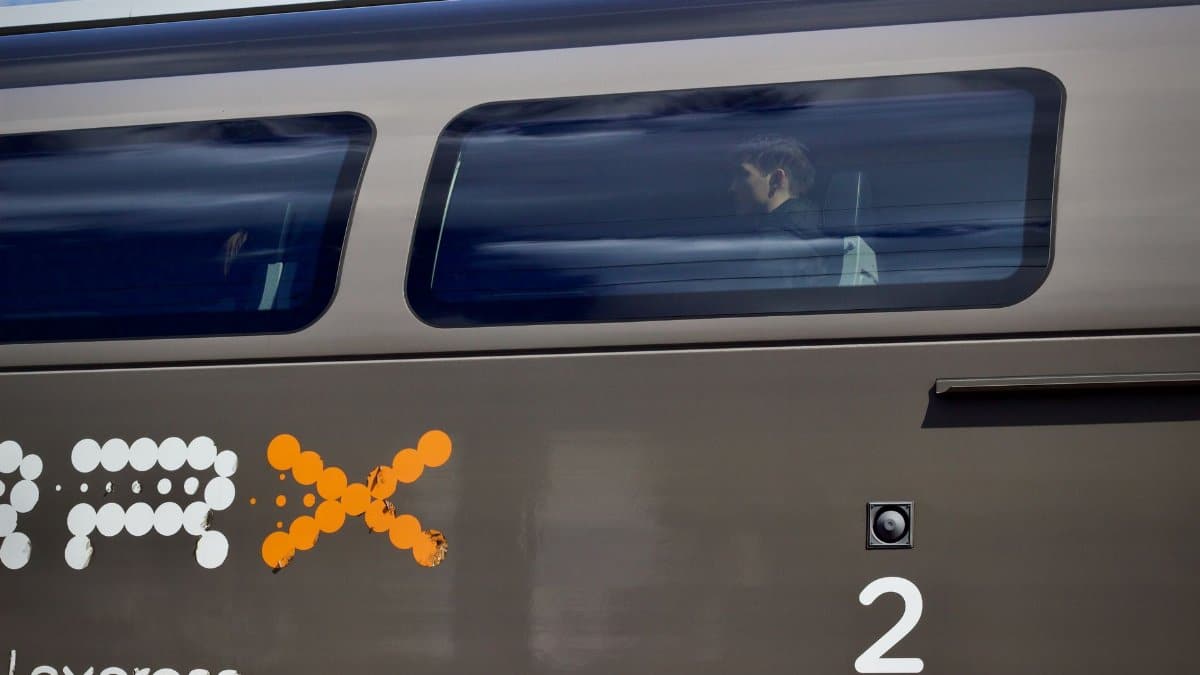 Profile of a passenger inside a sleek high-speed train with motion blur effect.