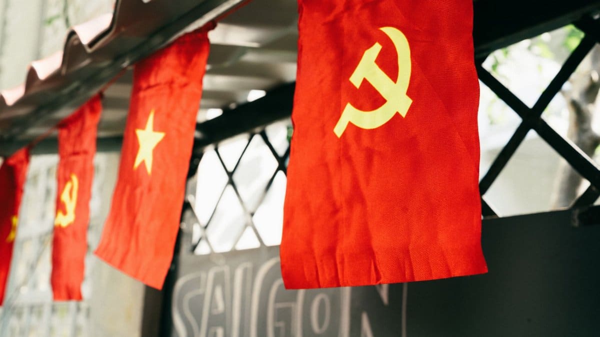 Vietnamese flag with hammer and sickle symbol displayed outdoors, representing communism in Saigon.