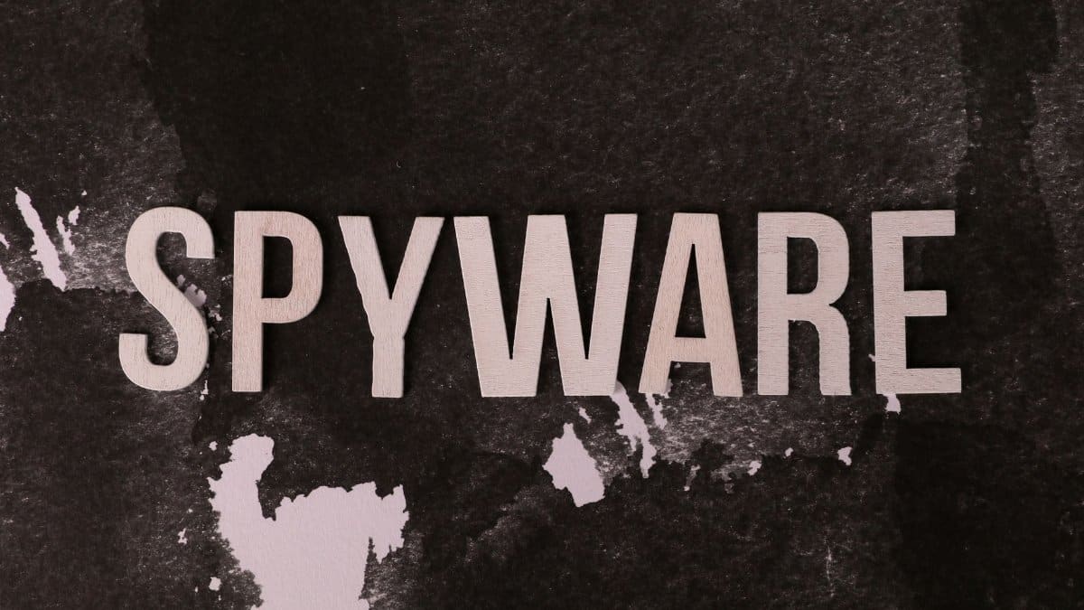 Black and white artistic depiction of the word SPYWARE against a textured background.