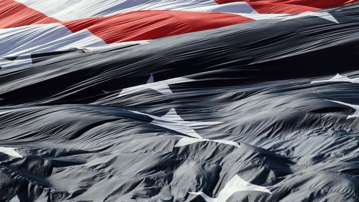 A detailed close-up of the American flag gracefully waving in the wind, showcasing its textures.