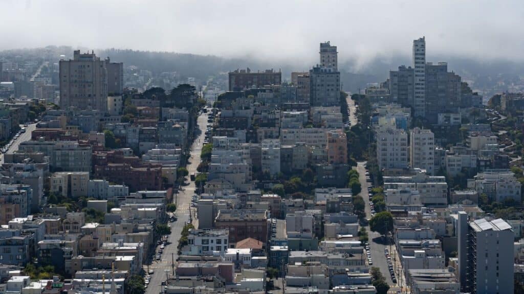 Aerial view of San Francisco's residential buildings and streets under fog.