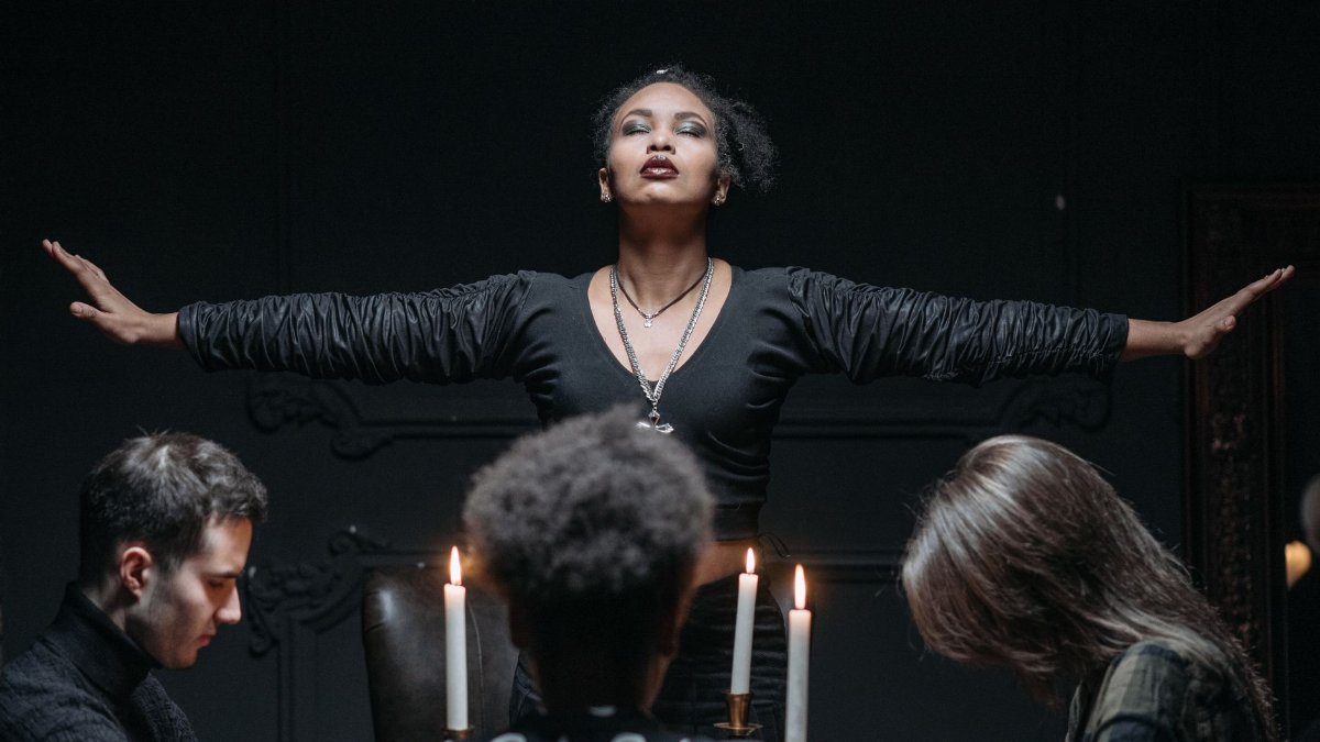 People engaged in a spiritual seance with candlelight, exploring mysticism and spiritualism.