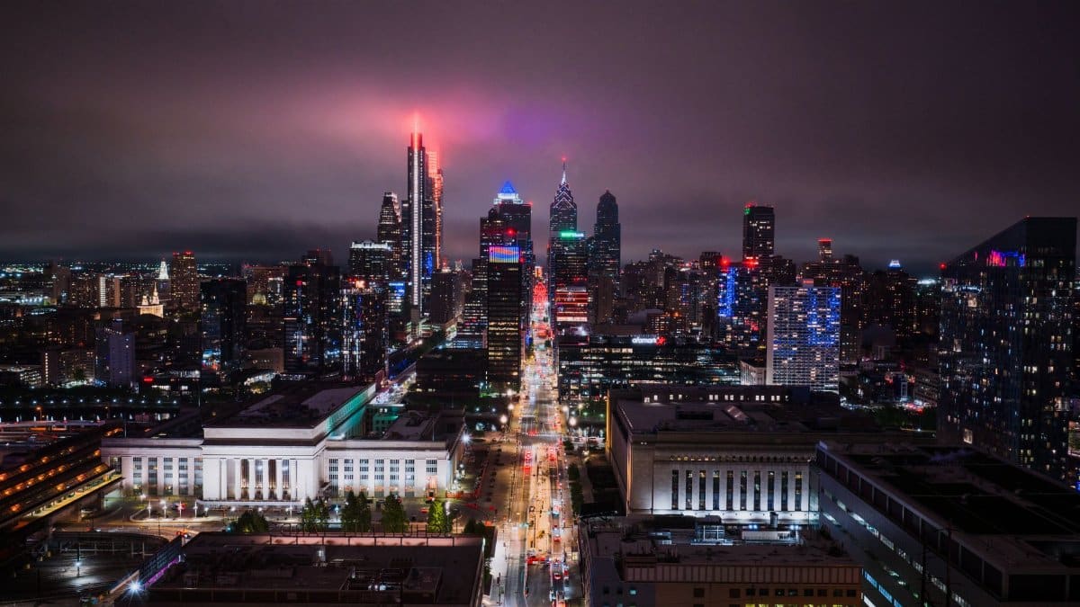 Stunning aerial view of Philadelphia's illuminated skyline at night, showcasing vibrant city lights.