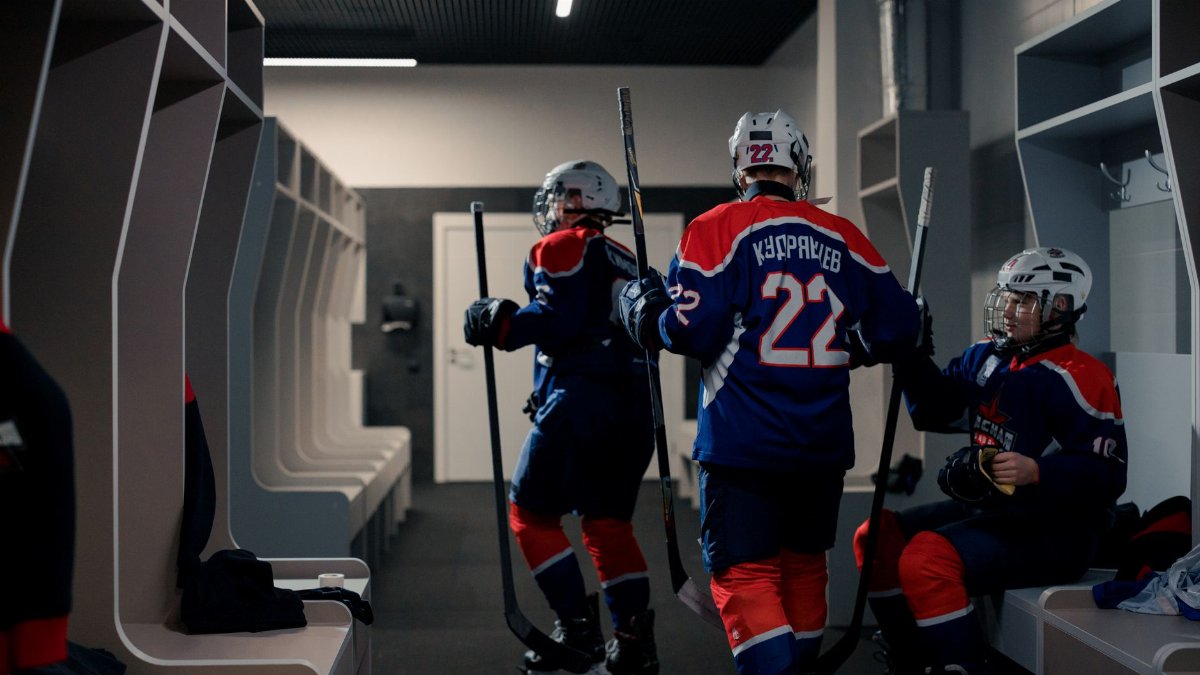 A team of hockey players getting ready in the locker room before the game.