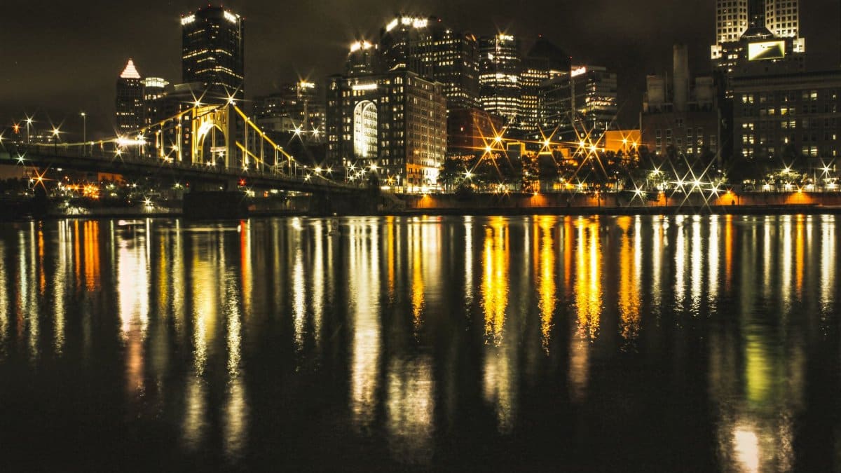 A breathtaking night view of a city skyline with reflections on the water.