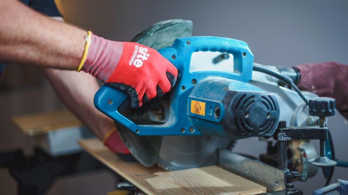 Carpenter using a circular saw to cut wood, showcasing precision craftsmanship.