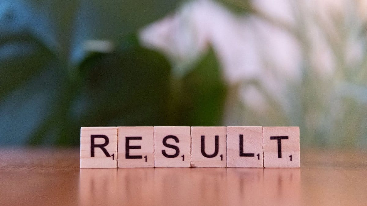 Wooden scrabble tiles arranged to spell RESULT on a wooden table.