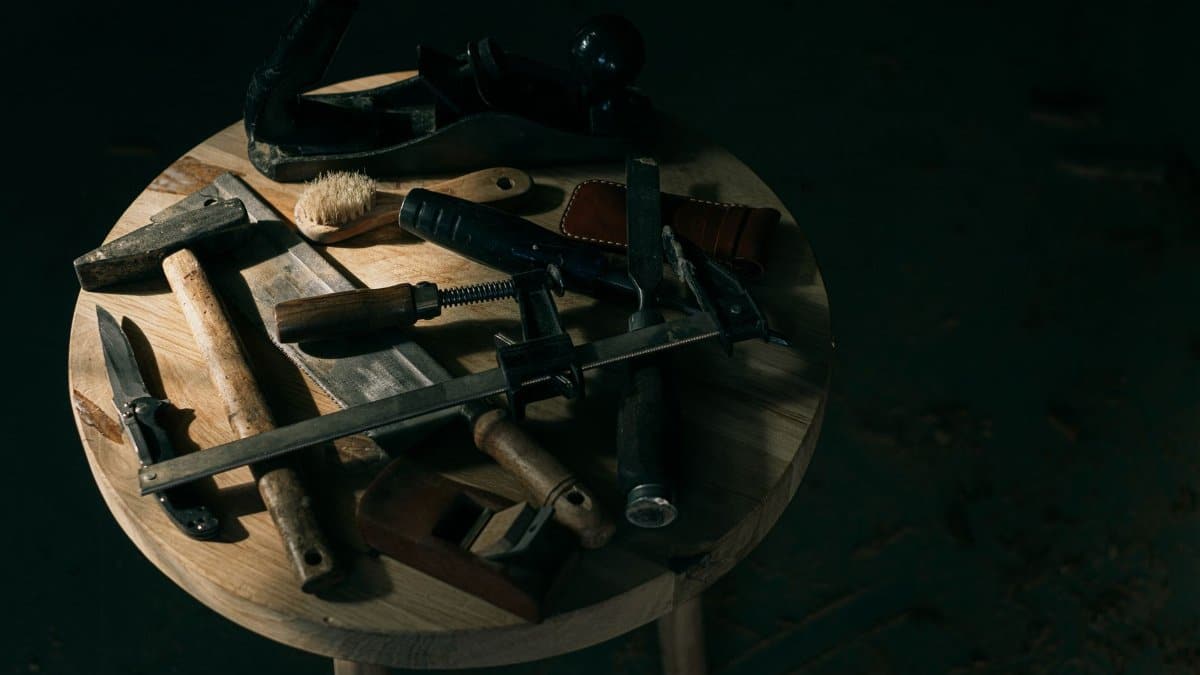 A selection of vintage woodworking tools displayed creatively on a round wooden table.