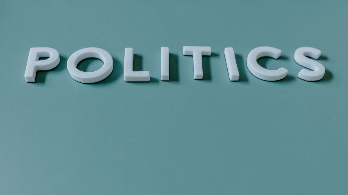 Close-up image of the word 'Politics' against a teal green background, highlighting political themes.