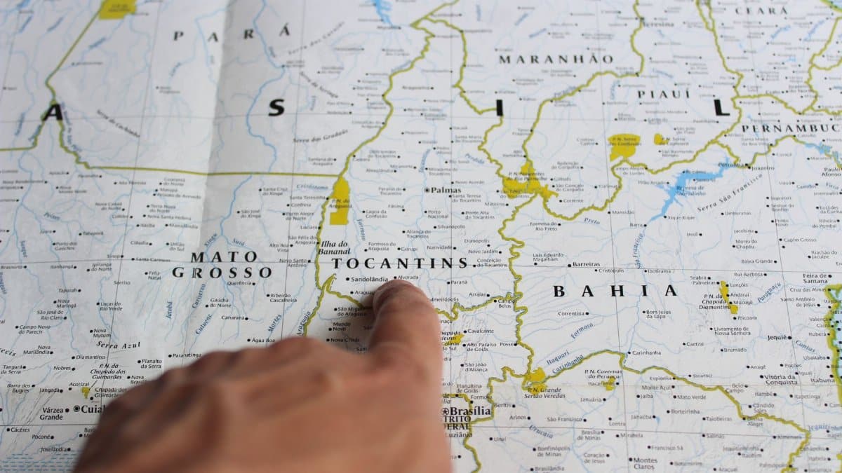 Close-up of a finger pointing to Tocantins on a map of Brazil.