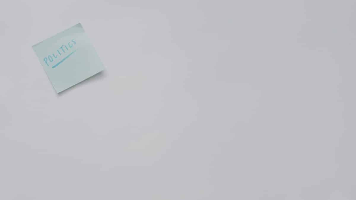 A simple sticky note with 'politics' written on it, offering ample copyspace.
