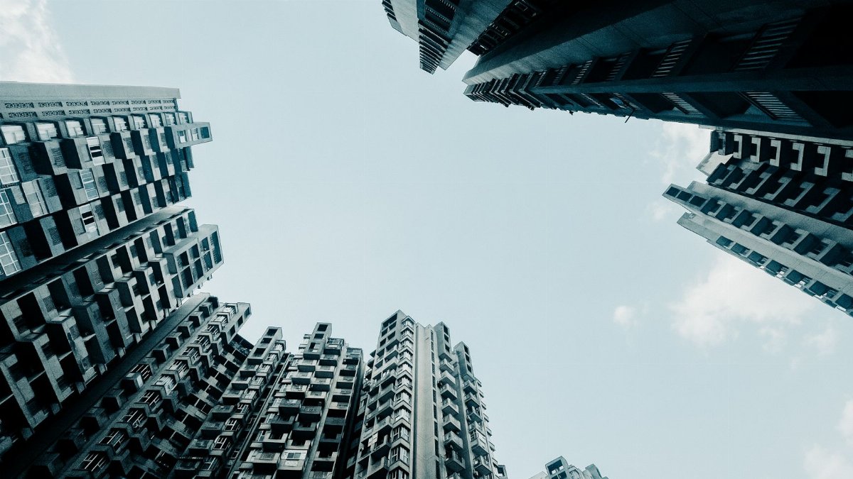 Dramatic low-angle shot of skyscrapers with a clear sky, capturing urban architecture.