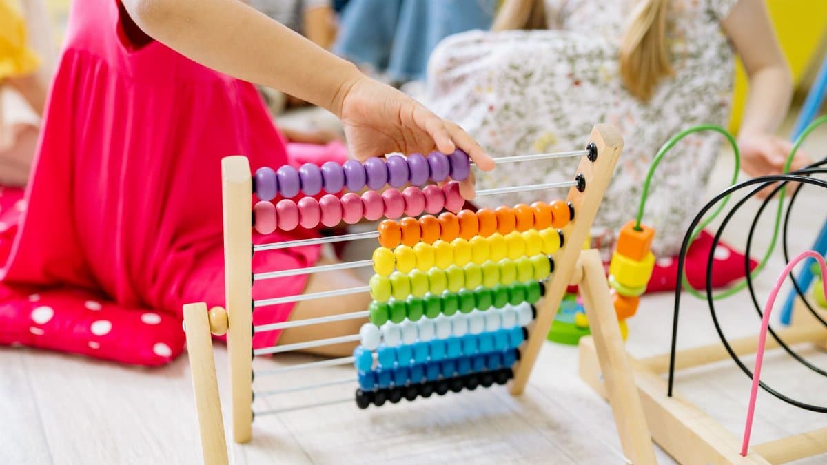 Children actively learning with a colorful abacus in a preschool setting, enhancing educational fun.