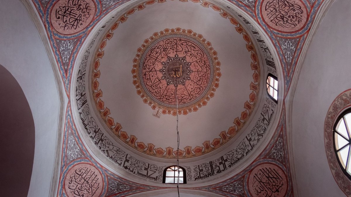 Stunning interior view of a decorated Islamic dome in Sarajevo, featuring Arabic calligraphy and geometric designs.