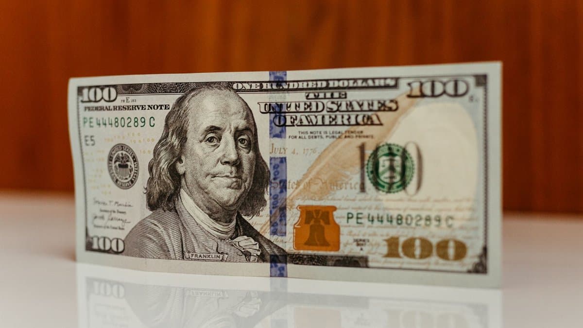 Detailed image of a US one hundred dollar bill featuring Benjamin Franklin.