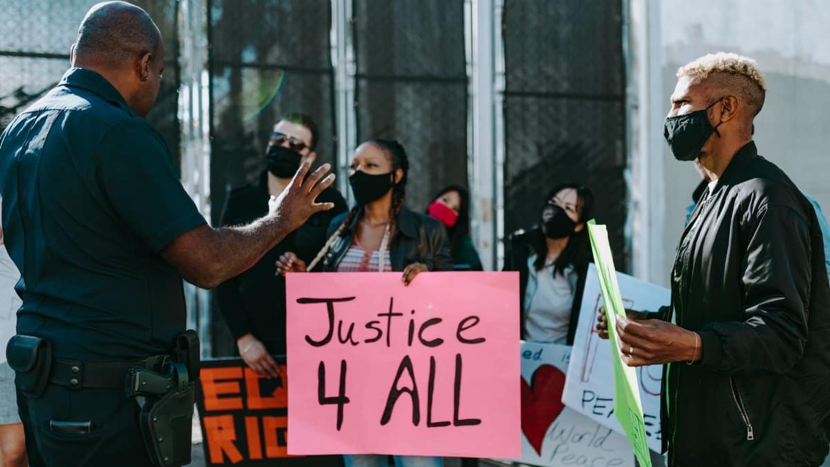 A diverse group holds signs advocating justice during a nonviolent protest.